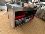 a large stainless steel counter with red bins on it