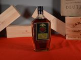 a bottle of liquor sitting on a table next to a wooden box