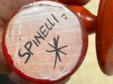 a person holding a small wooden object with writing on it