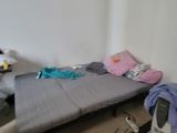 a small bed in the corner of a room next to a desk