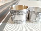 two silver cups that are sitting on a table