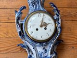 une horloge bleue et blanche accrochée à un mur en bois