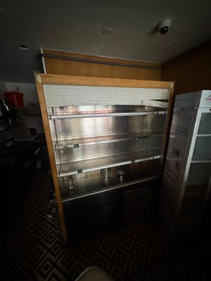 une photo d'un réfrigérateur vide dans une pièce sombre
