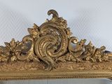 a mirror with a gold frame on the wall
