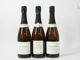 trois bouteilles de vin posées les unes à côté des autres sur une surface blanche