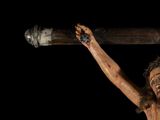 statue of jesus on the cross holding a baseball bat in his hand