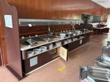 une grande cuisine avec beaucoup de vaisselle sur le plan de travail