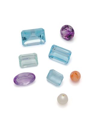 Plusieurs pierres de différentes couleurs sont disposées sur une surface blanche.