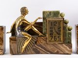 a statue of a man sitting on a bench with a clock