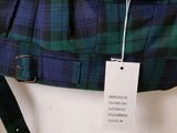 a green and black plaid jacket hanging on a wall