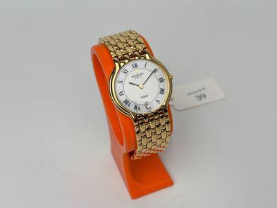 an image of a gold and white wrist watch on an orange stand