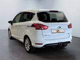 the rear end of a white car parked in a garage