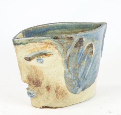 a close up of a vase with a face on it