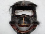 an image of a mask on a white surface with a black face