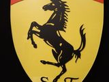 logo Ferrari sur un bouclier jaune orné d'une bande rouge, blanche et verte