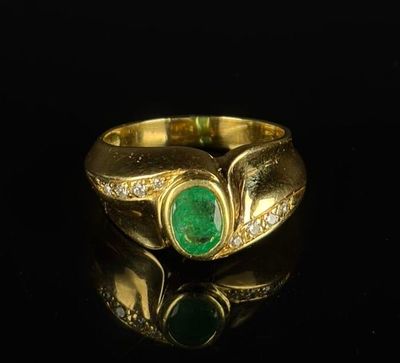a close up of a gold ring with a green stone