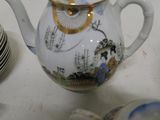a white tea pot with a gold rim and a blue and white design on it