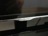 the samsung tv is sitting on a wooden table in front of a person
