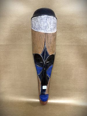 an image of a wooden mask hanging on a wall