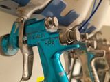 a blue spray gun hanging from a wall in a room