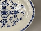 a blue and white plate with a flower design on it