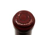 a close up of a bottle of wine on a white surface