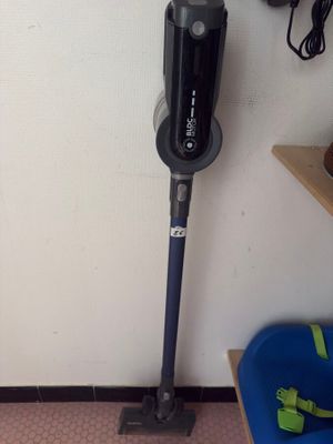 a vacuum that is sitting on the floor next to a blue chair