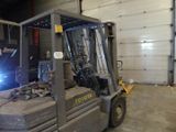 a forklift with a welder on it in a warehouse