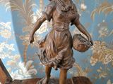 a statue of a woman holding a basket on a table
