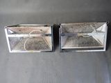 two metal boxes that are sitting on a gray surface