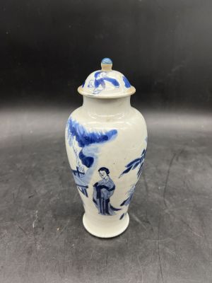 a blue and white vase with a lid on a table