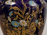 a blue vase with gold and blue flowers on it