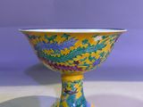 yellow and blue bowl with dragon design on it on a table