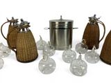 several glass vases and a metal kettle on a white surface
