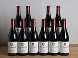six bouteilles de vin rouge sont alignées sur une table en bois