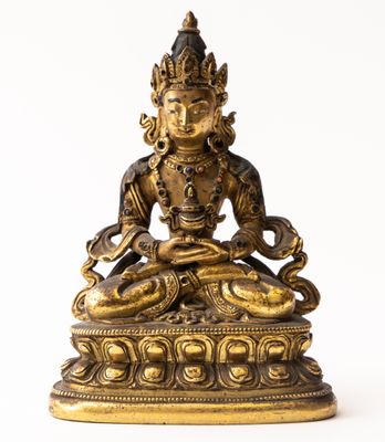 une statue en or représentant une femme assise sur un lotus