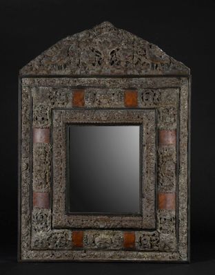 un vieux miroir avec un cadre décoratif et un fond noir