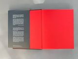 a red book opened on a white surface