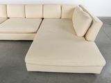 a white couch with a chaise on it in a room