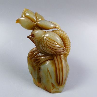 two birds sitting on top of a vase on a white surface
