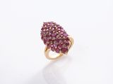 un gros plan d'une bague ornée de pierres roses sur un fond blanc