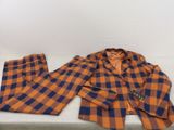 un costume à carreaux orange et bleu posé sur une table blanche