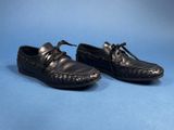 a pair of black leather shoes on a blue background
