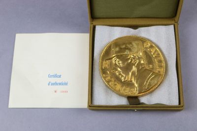une médaille d'or posée dans une boîte sur une table
