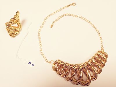 a gold necklace and a pair of earrings sitting on a table