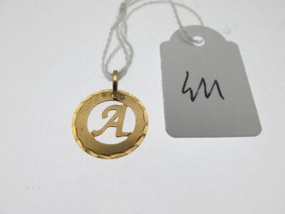 un pendentif plaqué or sur lequel figure la lettre « a »