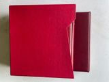 deux livres rouges posés l'un sur l'autre sur une table
