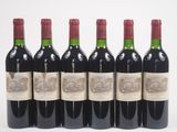 six bouteilles de vin rouge alignées sur une surface blanche
