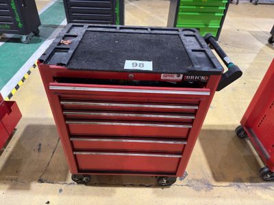 a close up of a red tool box on wheels in a warehouse
