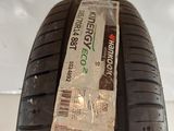a close up of a tire on a white surface with a tag on it